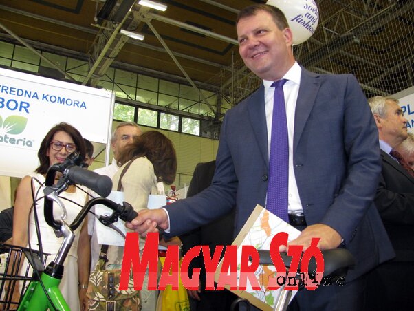 Igor Mirović kiállításszemlén, a tartományi kormányfő a Capriolo saját tervezésű biciklijét tartja a kezében (Kecskés István felvétele)