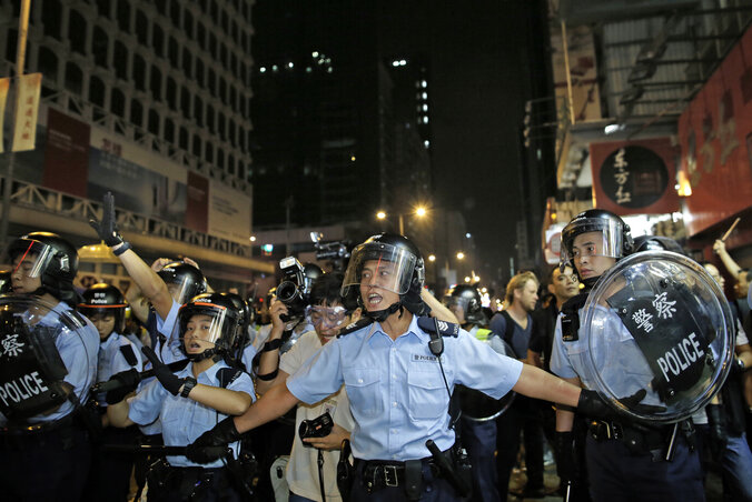 A rohamrendőrök kordonja igyekszik útját állni a tüntetőknek a Mong Kok negyedben (Fotó:  Beta/AP)