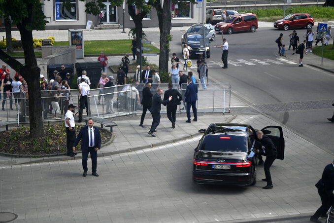 A megsebesített szlovák kormányfőt testőrei az autójába viszik (Fotó: Beta/AP/TASR)