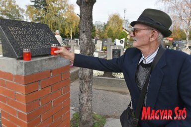 Sörös József az emlékoszlopra helyezi a gyertyát (Ótos András felvétele)