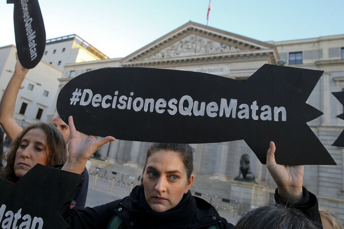 Spanyol aktivista „gyilkos döntések” felirartú bomba-moilinóval tiltakozik a madridi parlament előtt, a spanyol fegyvereladások ellen tiltakozva (fotó: AP/Beta)