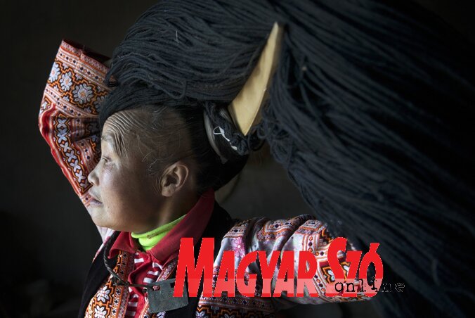 A miao törzs tagja fejdíszét készíti elő – Kujcsou, Kína