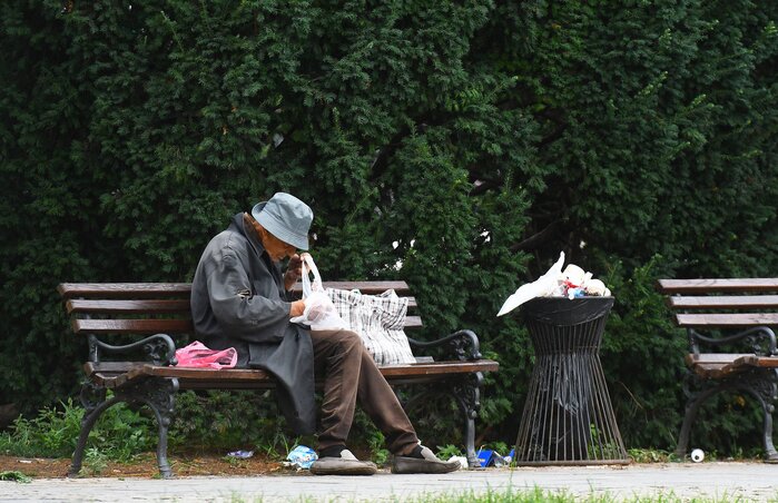 Novi Sad, 26.07.2023. - Beskucnik gleda svoje stvari dok sedi na klupi na novosadskom parku. (BETAPHOTO/DRAGAN GOJIC)