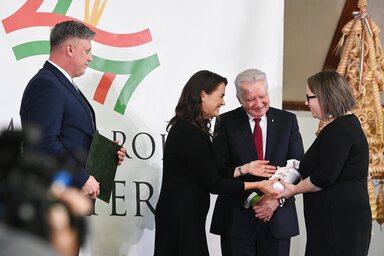 Novák Katalin köztársasági elnök jelképesen átnyújtja a búzaadományt Katona Viktóriának, a Magyar Református Szeretetszolgálat Alapítvány ügyvezető helyettesének. Jobbról Jakab István, balról  Győrffy Balázs (Fotó: MTI)