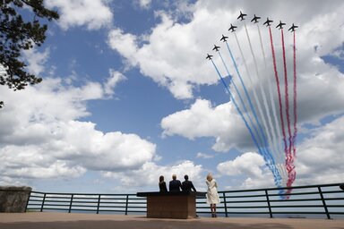 A francia és az amerikai elnöki házaspár figyeli, amint a francia légierő akrobata köteléke elhúz az amerikai katonák normandiai – Colleville-sur-Mer partján fekvő – temetője felett (Fotó: AP/Beta)